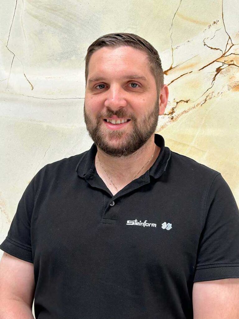 Valentin Hirt, Leiter Innendienst bei Steinform, vor Naturstein-Hintergrund